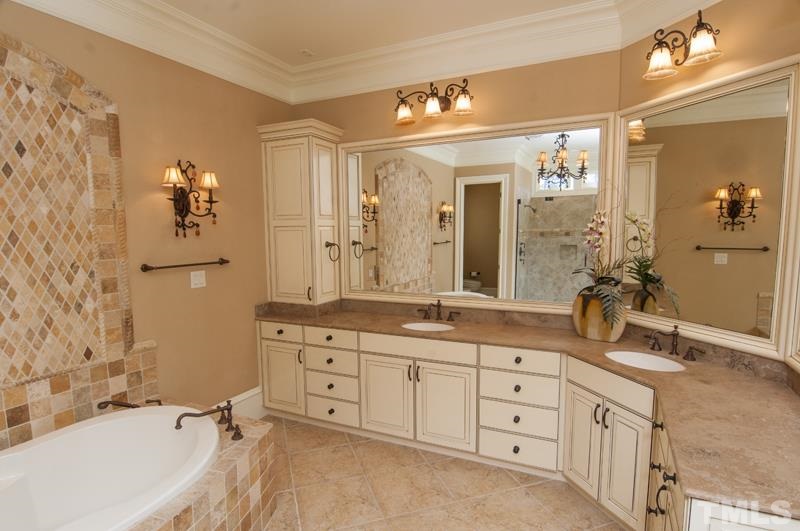 11200 Jonas Ridge Lane Raleigh, NC 27613 - Photo 7 of 25 a spacious bathroom with a granite countertop sink mirror and a bathtub