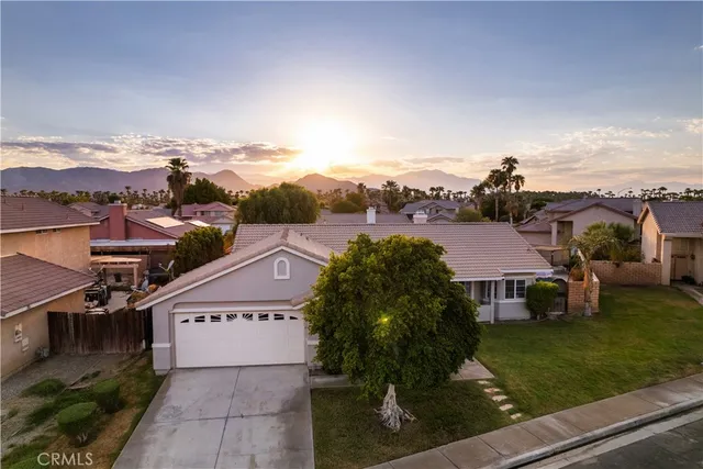 an aerial view of residential houses with outdoor space and trees