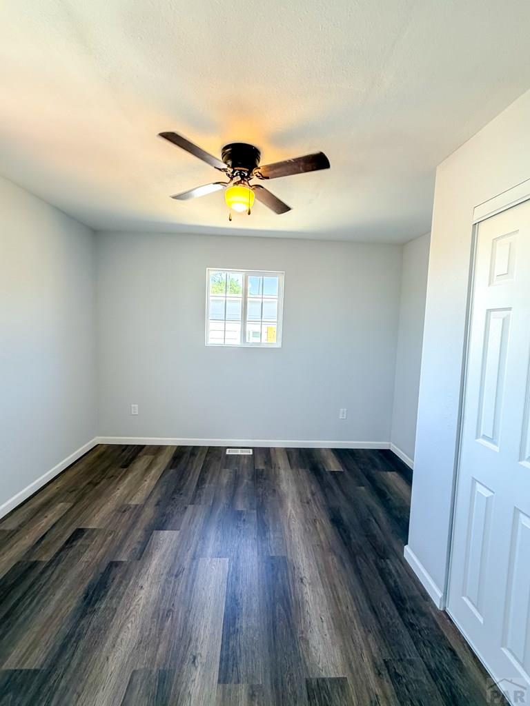 809 West 4th Street La Junta, CO 81050 - Photo 8 of 15 an empty room with wooden floor and windows