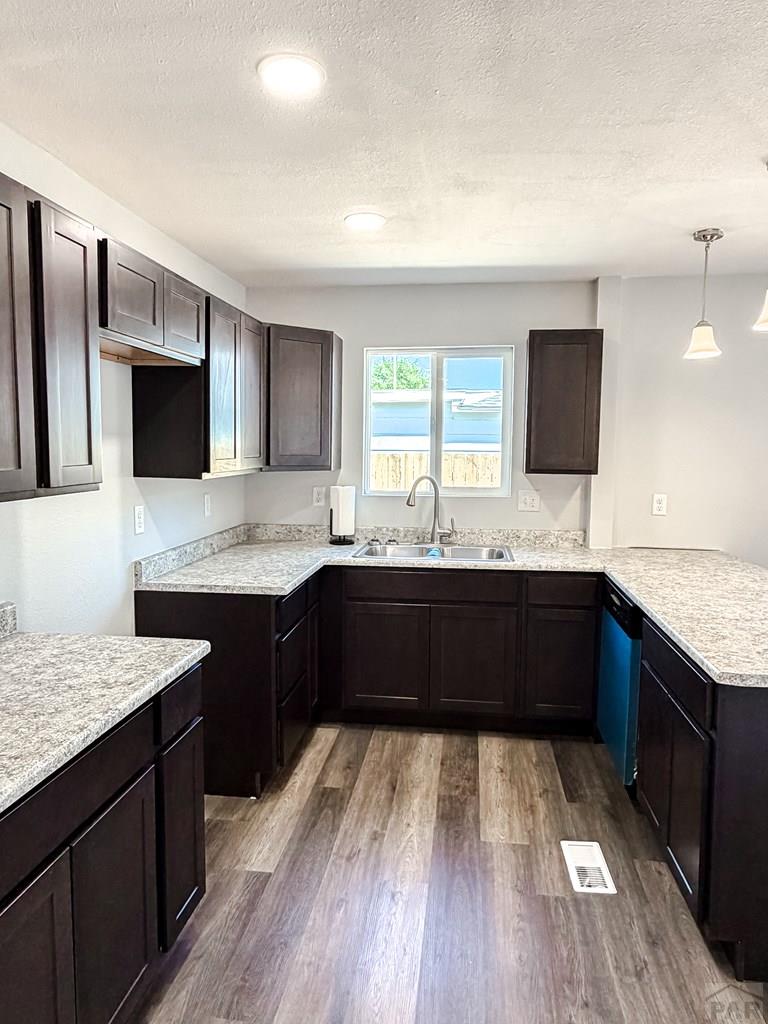 809 West 4th Street La Junta, CO 81050 - Photo 10 of 15 a kitchen with granite countertop stainless steel appliances a sink stove top oven and wooden floor