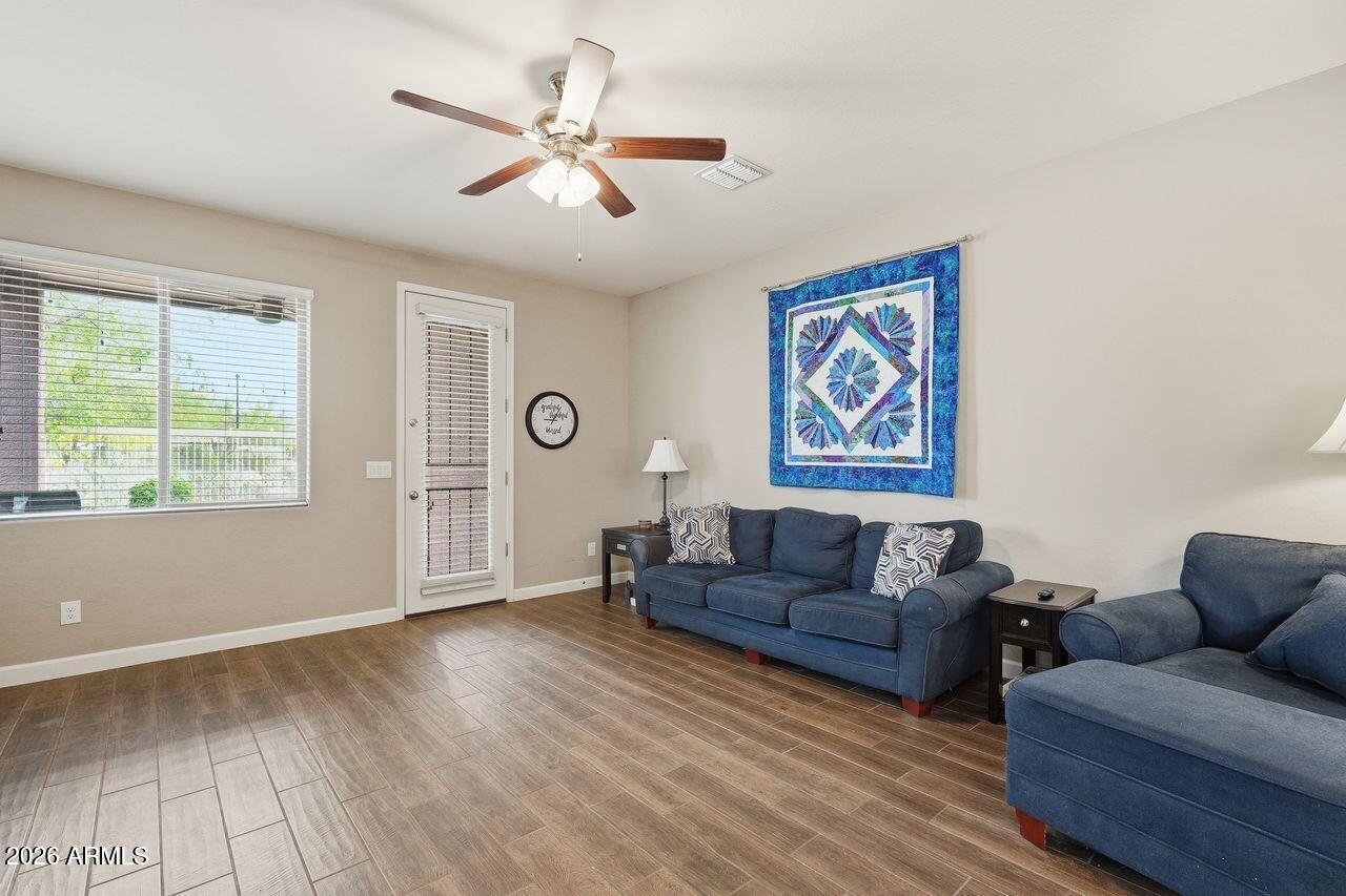 23602 West Ripple Road Buckeye, AZ 85326 - Photo 7 of 38 a living room with couches and a large window with wooden floor