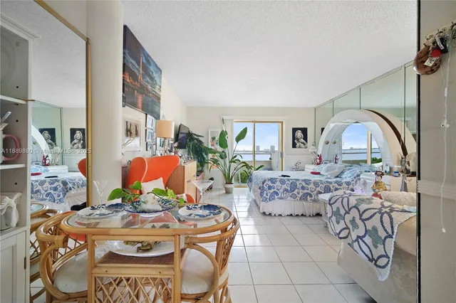 a bedroom with a bed a dresser next to a potted plant