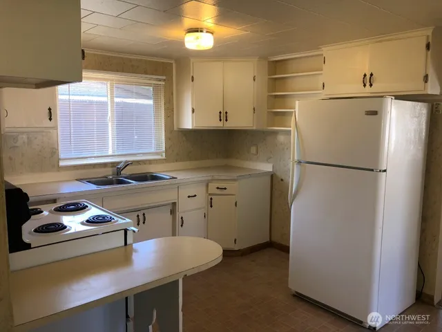 a kitchen with a refrigerator a stove a sink and a stove