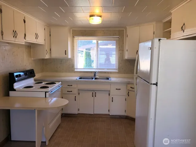 a kitchen with stainless steel appliances a stove a refrigerator sink and cabinets