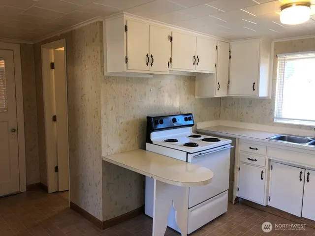 a kitchen with white cabinets and white appliances