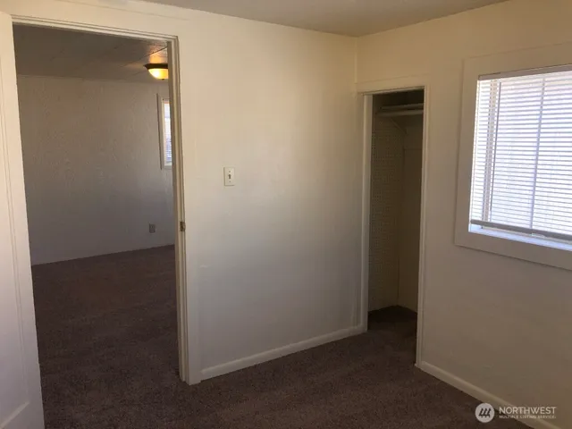 an empty room with windows and closet