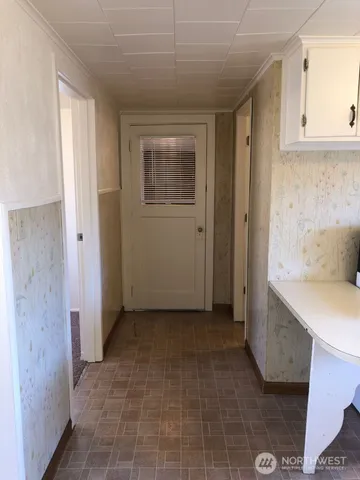 a view of an empty room with closet and a window