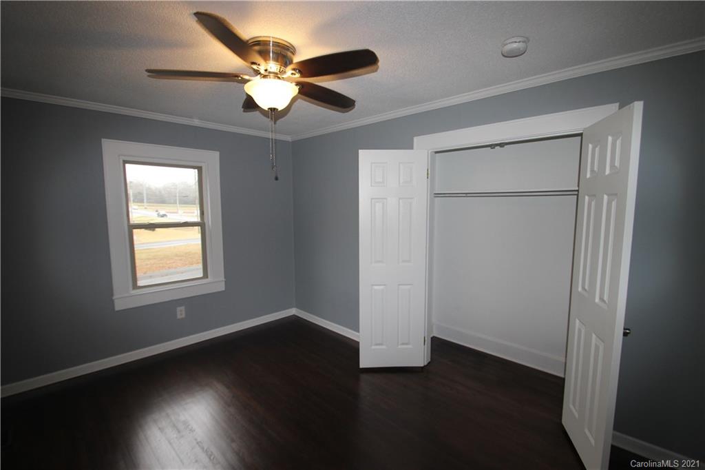 4645 Poplar Tent Road Concord, NC 28027 - Photo 14 of 25 a view of an empty room with wooden floor and a window
