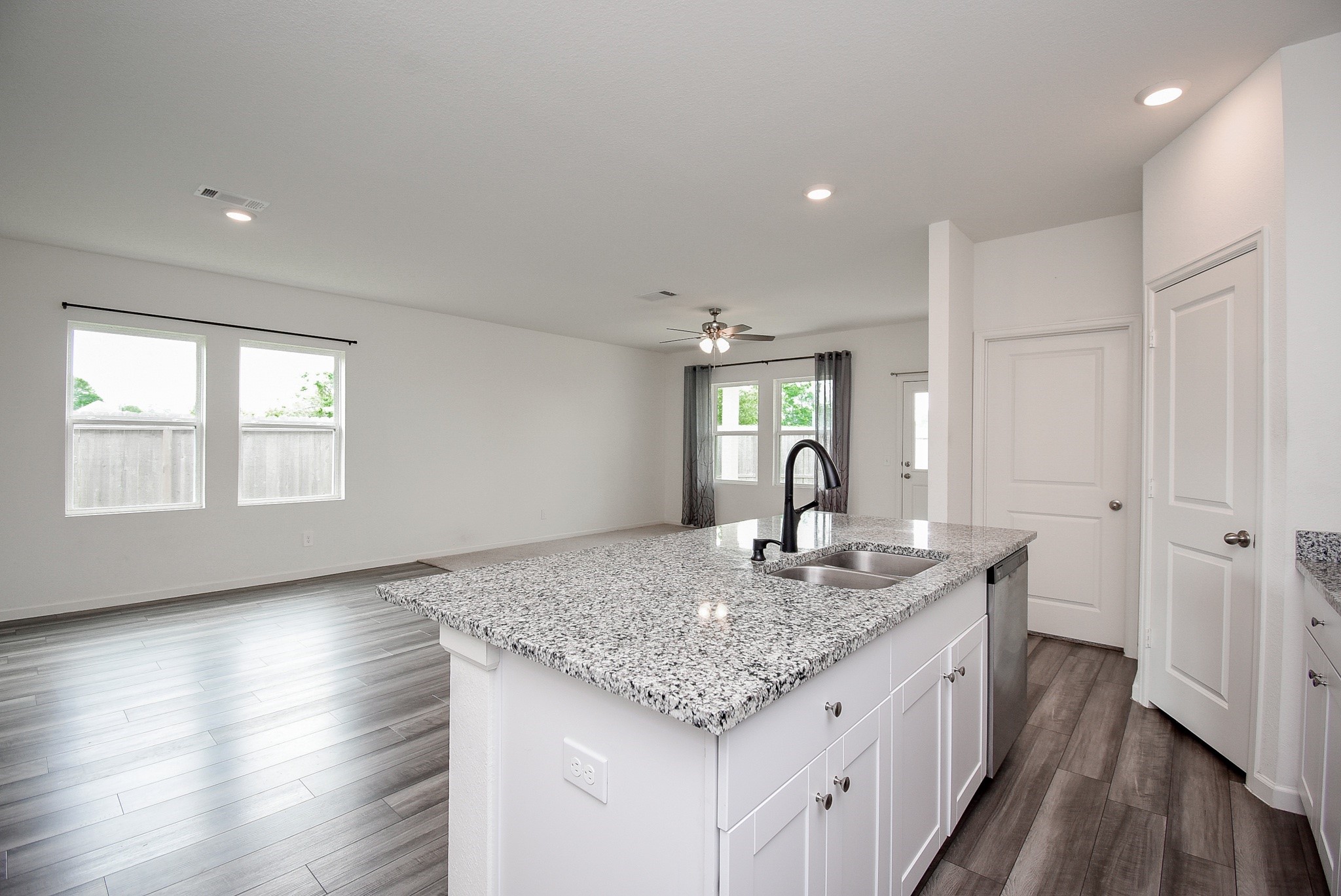 13542 Kinsman Road Houston, TX 77049 - Photo 9 of 43 a kitchen with granite countertop kitchen island wooden floors granite counter tops and white appliances