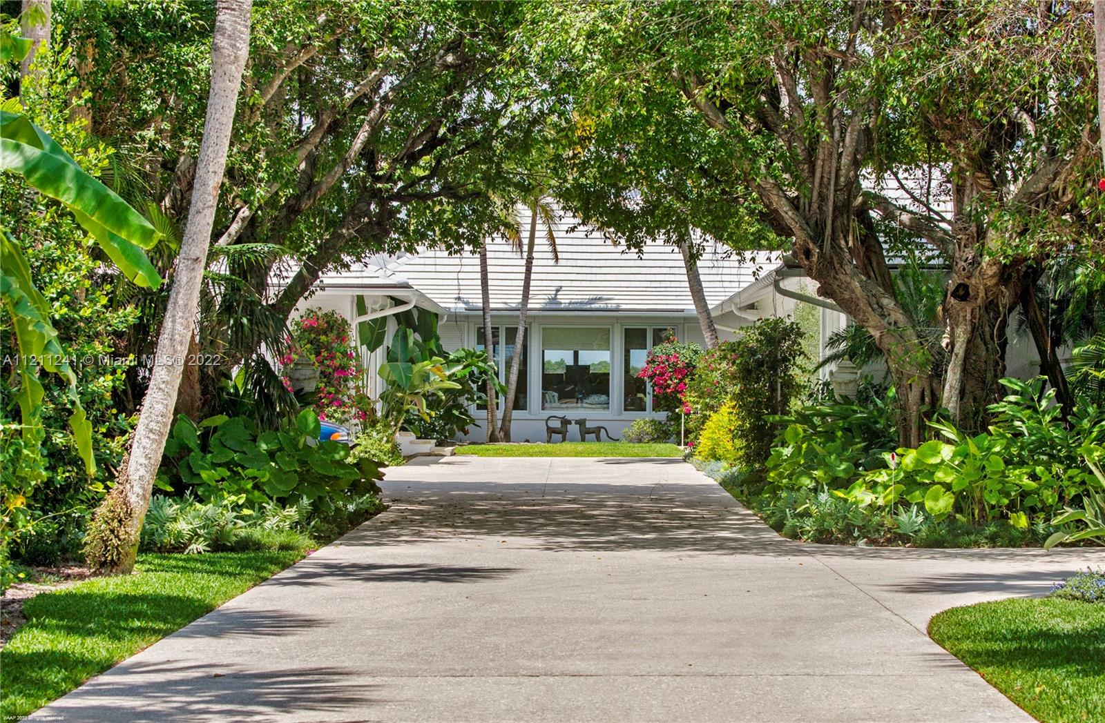 318 South Beach Road Hobe Sound, FL 33455 - Photo 25 of 69 a front view of a house with a yard and trees