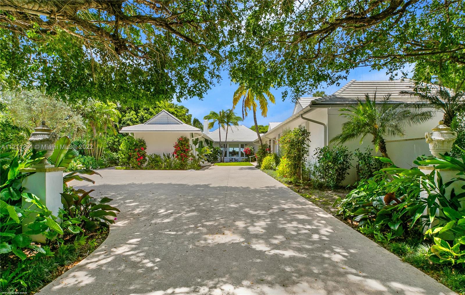 318 South Beach Road Hobe Sound, FL 33455 - Photo 26 of 69 a front view of a house with a yard and a garage