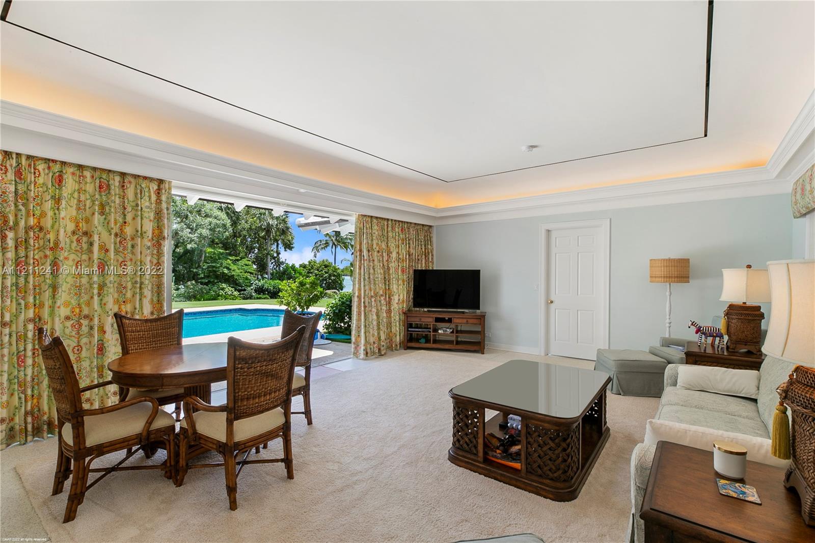 318 South Beach Road Hobe Sound, FL 33455 - Photo 54 of 69 a living room with furniture a flat screen tv and a floor to ceiling window