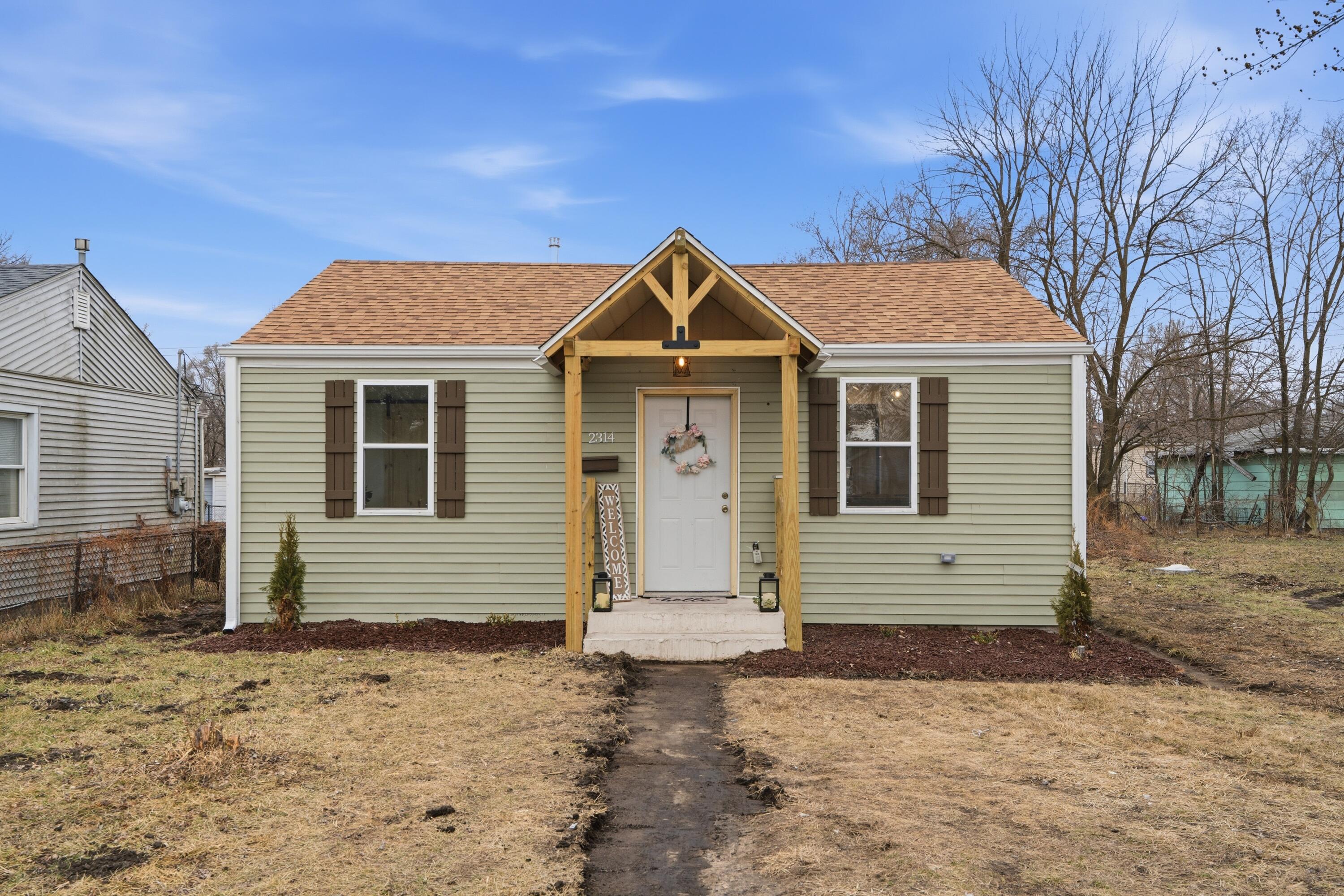 2314 Kentucky Street Gary, IN 46407 - Photo 1 of 16 a front view of a house with a yard