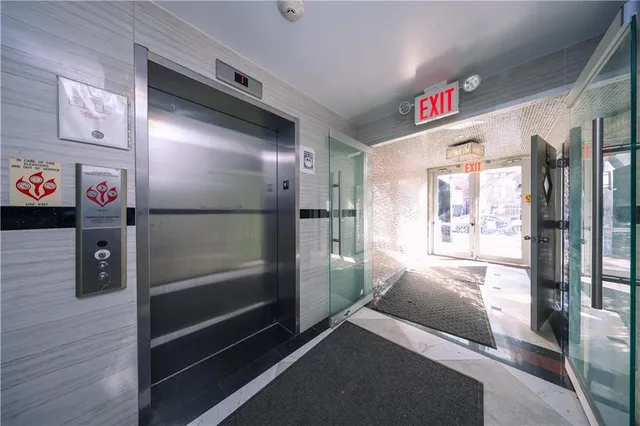 a view of a hallway with a door and wooden floor
