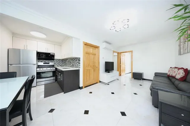 a kitchen with kitchen island a stove a sink a dining table and chairs