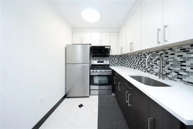 a kitchen with granite countertop a refrigerator and a sink
