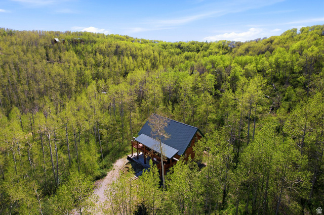 2096 South Aspen Ridge Coalville, UT 84017 - Photo 4 of 44 Wood-sided home featuring a dark metal roof, elevated porch, and surrounding mature trees