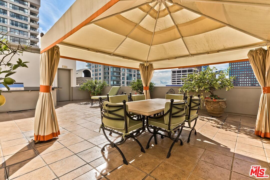 10795 Wilshire Boulevard, Unit 403 Los Angeles, CA 90024 - Photo 27 of 27 a patio with a table and chairs under an umbrella