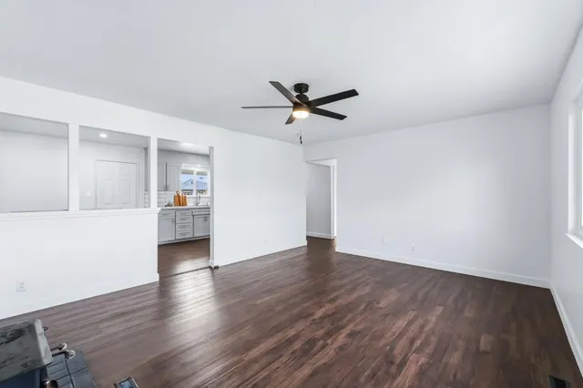 an empty room with wooden floor a fireplace and a window