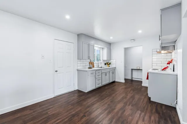 a kitchen with a refrigerator and wooden floor