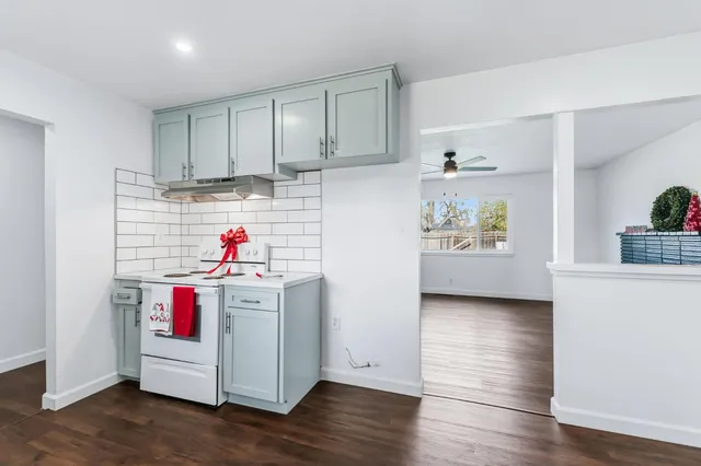 a utility room with cabinets and wooden floor