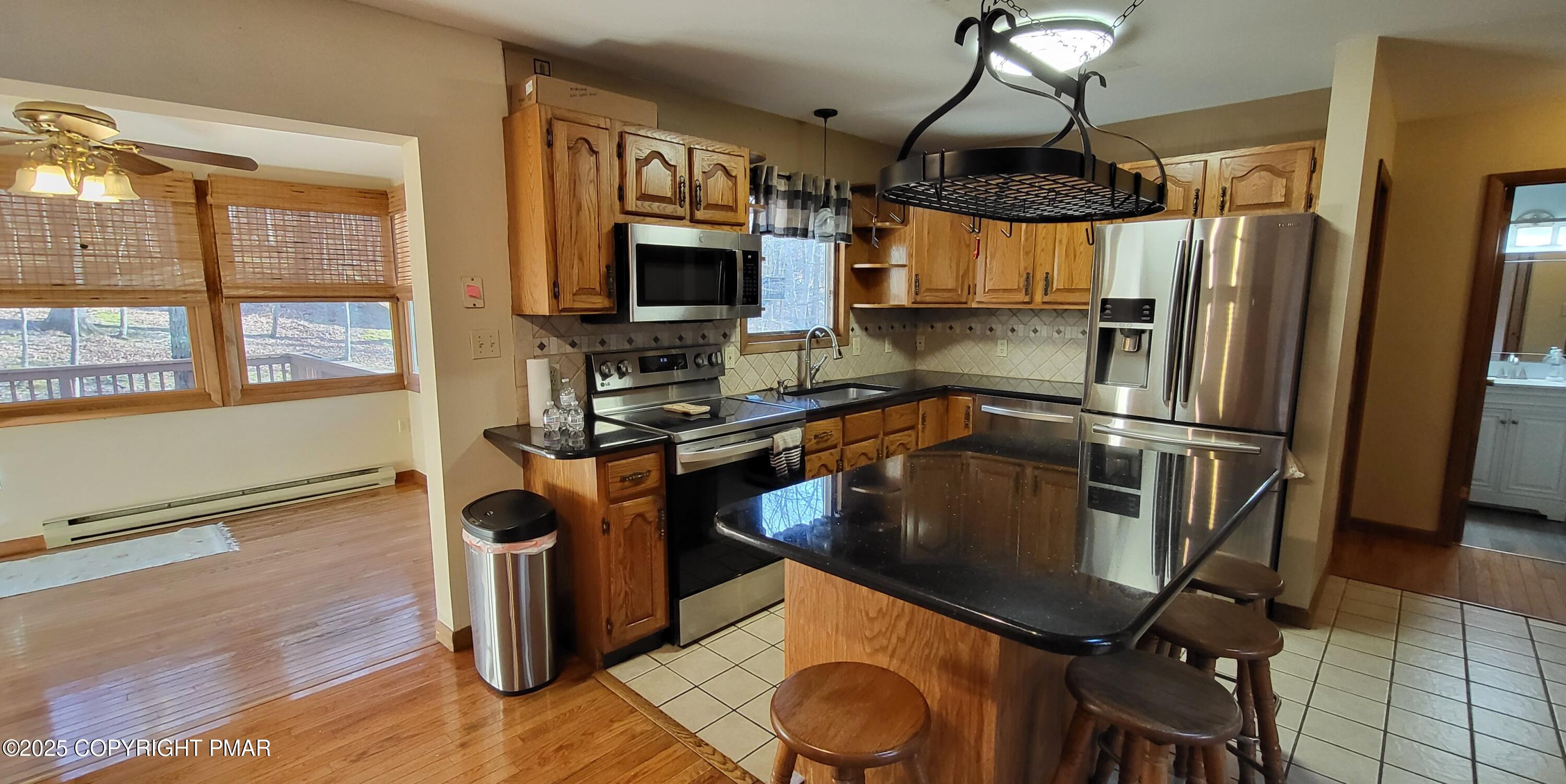 228 Edinburgh Road Bushkill, PA 18324 - Photo 9 of 77 a kitchen with stainless steel appliances granite countertop a sink a stove and a refrigerator