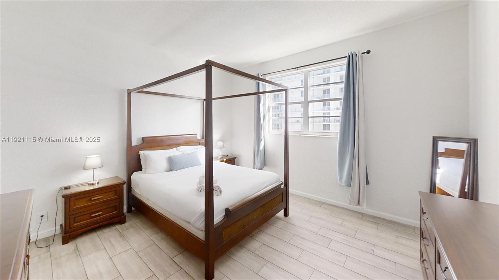 4001 South Ocean Drive, Unit PH7 Hollywood, FL 33019 - Photo 11 of 14 a bedroom with a bed and wooden floor