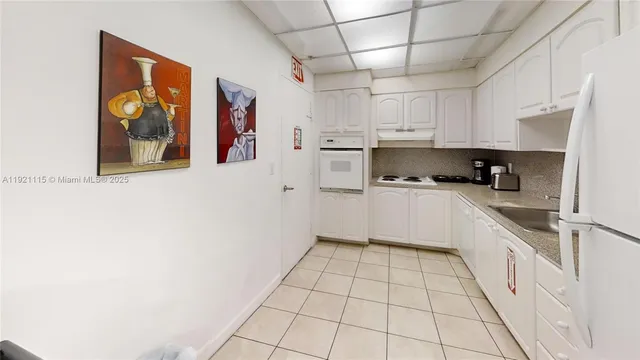 a kitchen with stainless steel appliances a stove a sink and white cabinets