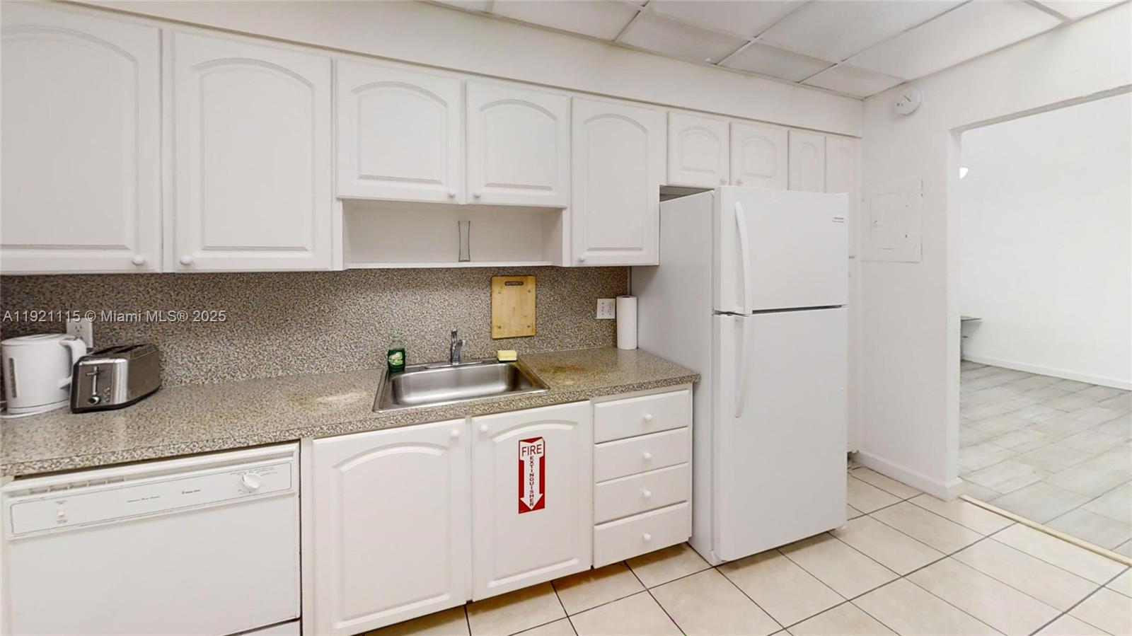 4001 South Ocean Drive, Unit PH7 Hollywood, FL 33019 - Photo 4 of 14 a kitchen with granite countertop white cabinets and white appliances