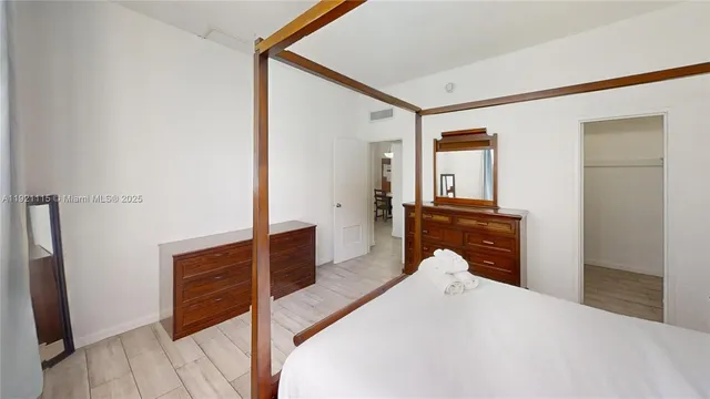 a bedroom with a bed and dresser with mirror