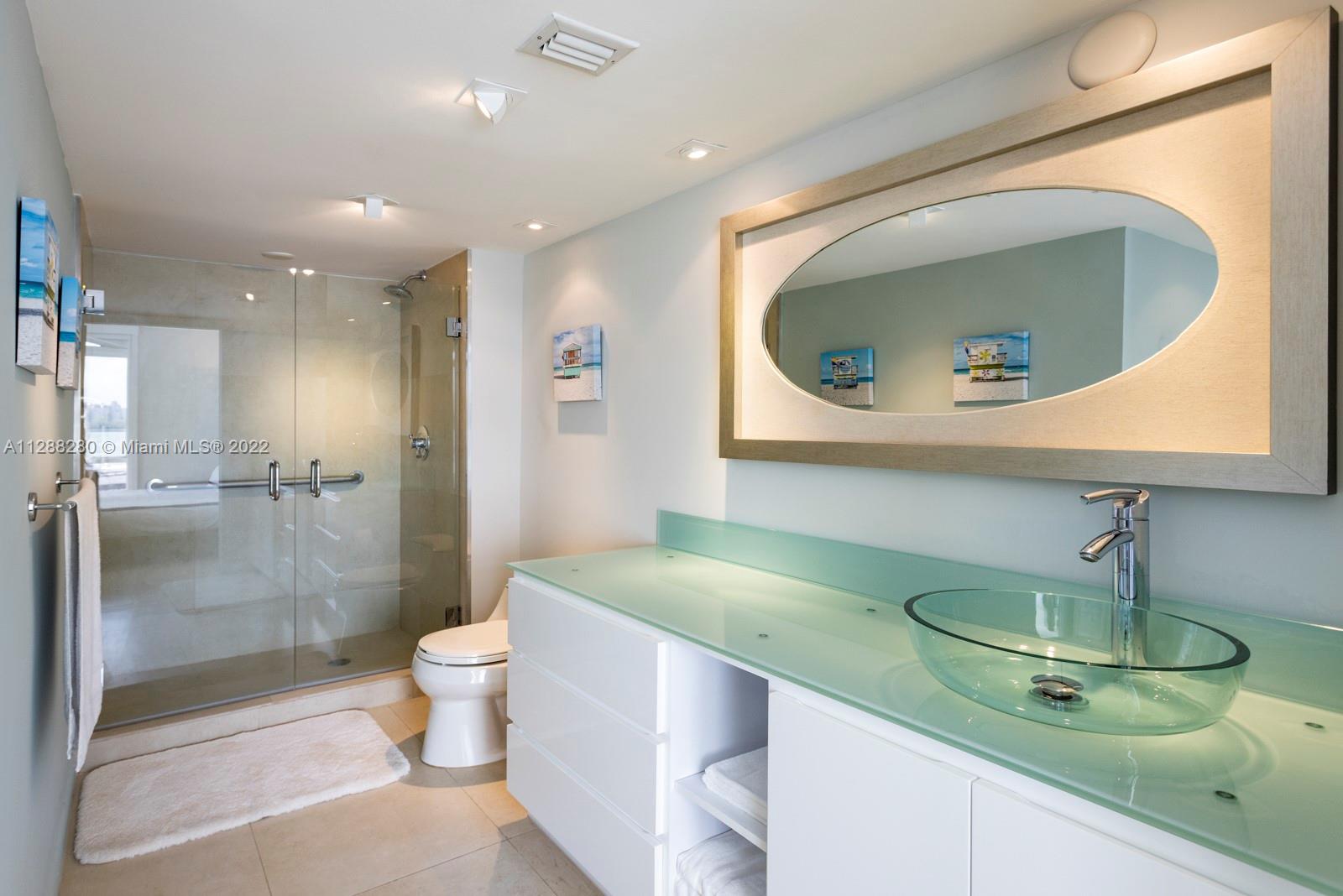 90 Alton Road, Unit 4 Miami Beach, FL 33139 - Photo 13 of 20 a bathroom with a toilet a sink and mirror