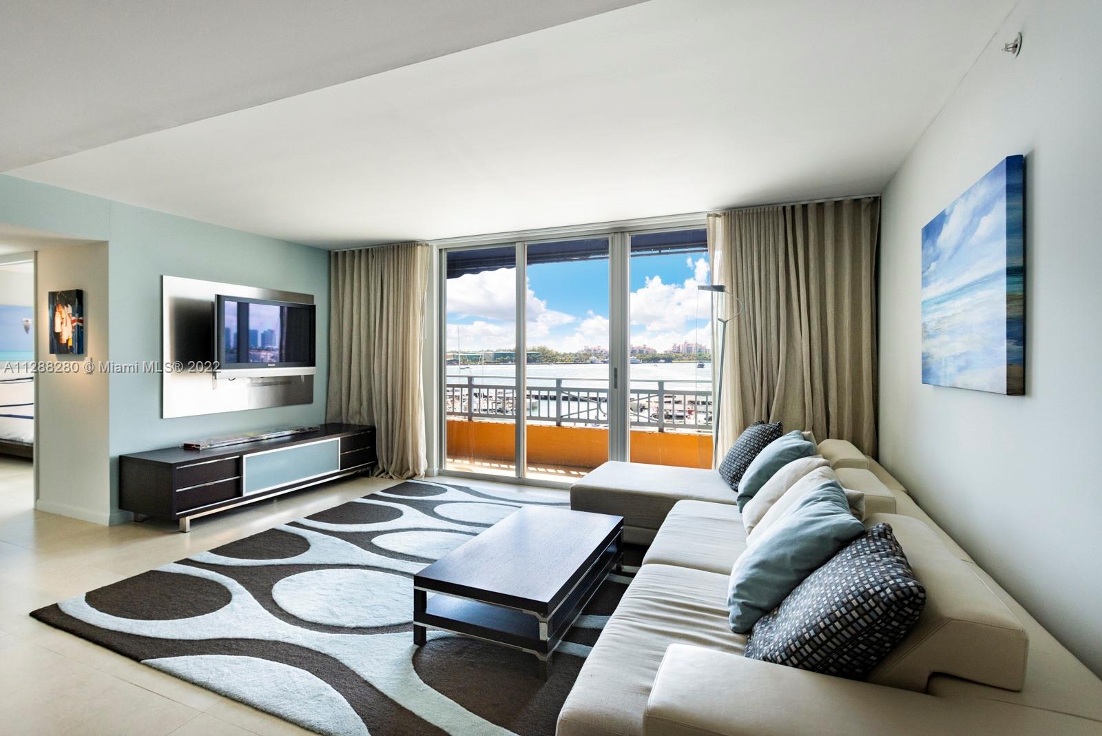 90 Alton Road, Unit 4 Miami Beach, FL 33139 - Photo 5 of 20 a living room with furniture flat screen tv and a large window