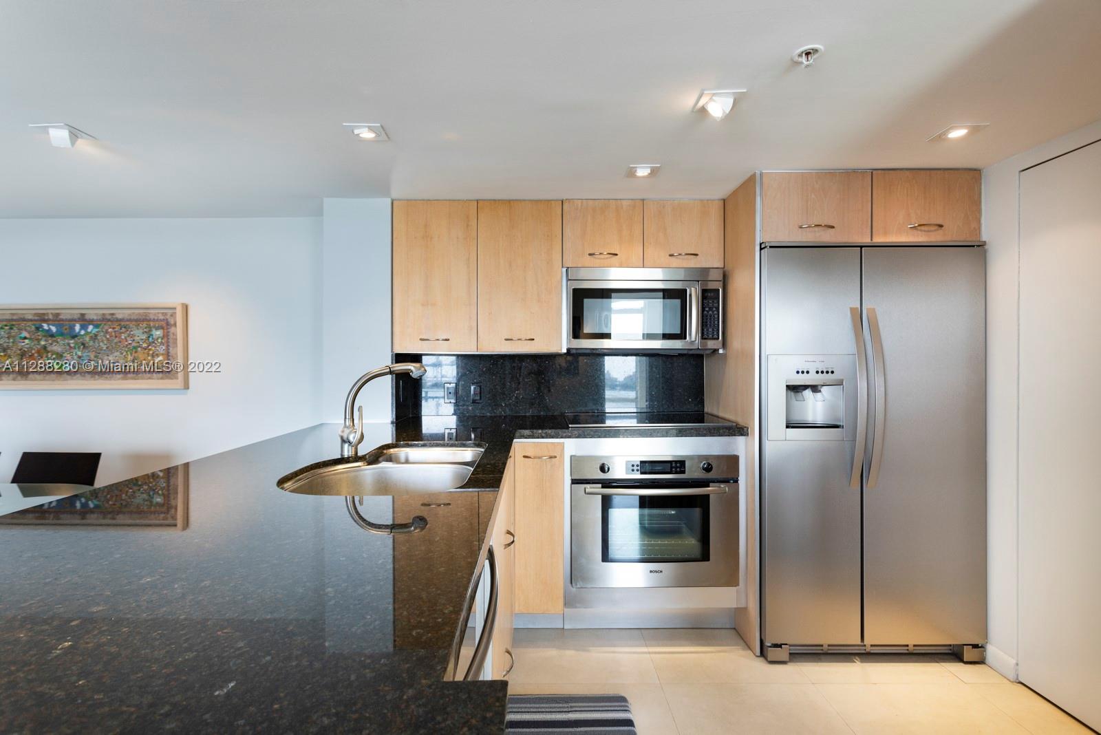 90 Alton Road, Unit 4 Miami Beach, FL 33139 - Photo 8 of 20 a kitchen with a refrigerator and a stove top oven