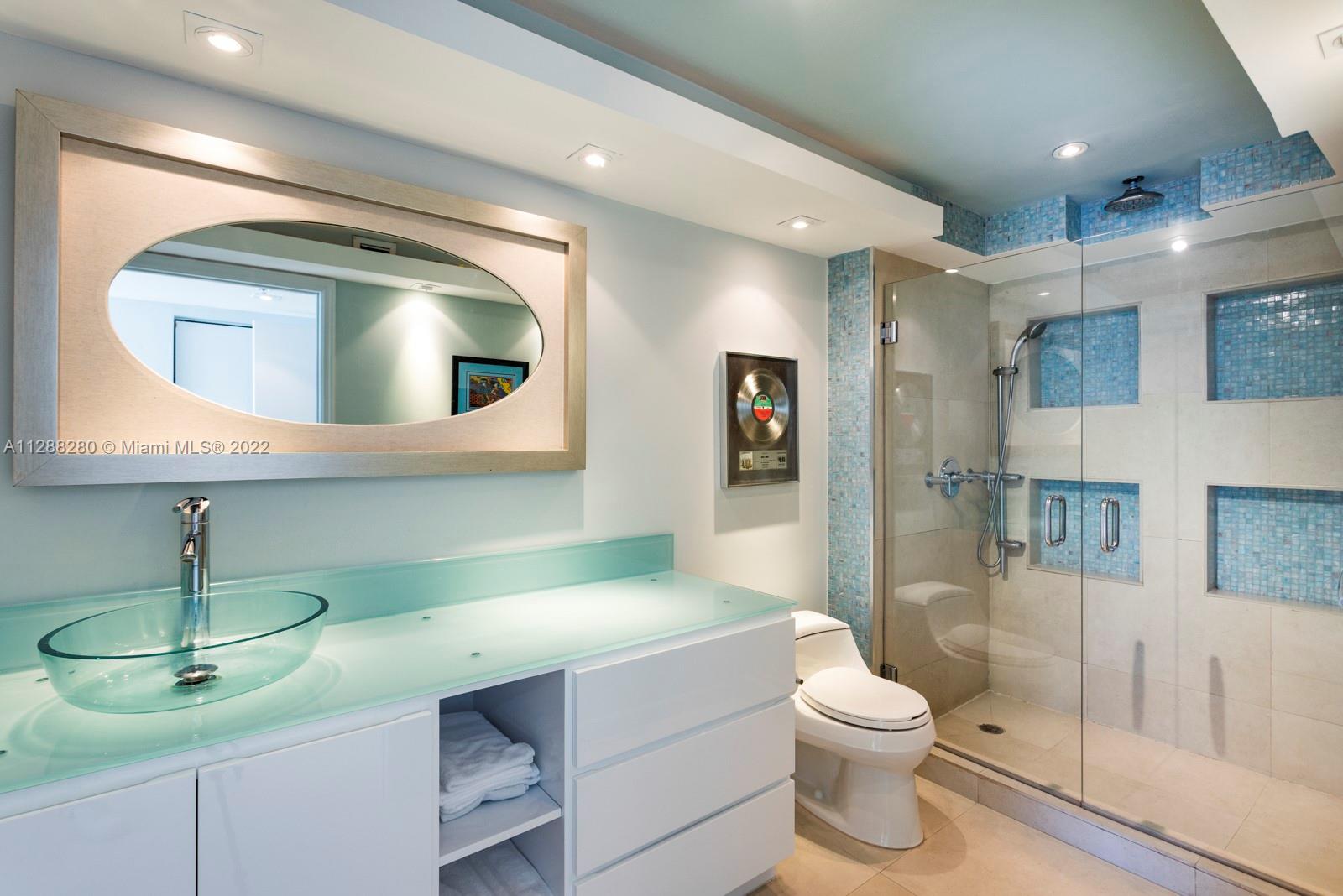 90 Alton Road, Unit 4 Miami Beach, FL 33139 - Photo 10 of 20 a bathroom with a toilet sink and mirror