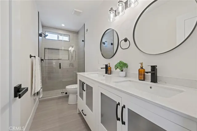 a bathroom with a double vanity sink mirror and a toilet