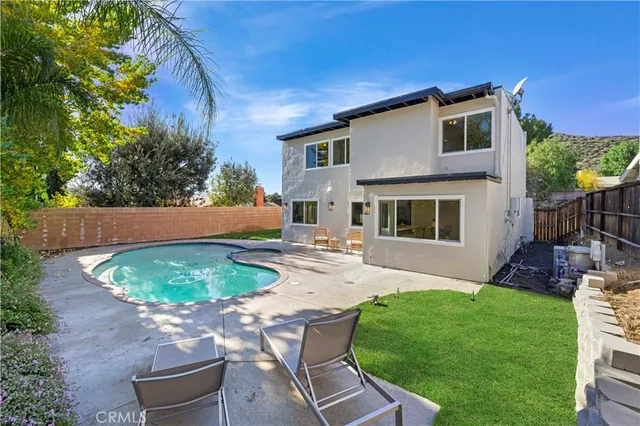 a view of a backyard with table and chairs potted plants and wooden fence