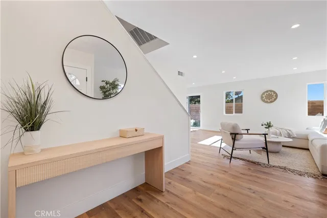 a living room with furniture a window and wooden floor