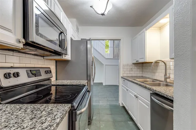 a kitchen with a stove a sink and a refrigerator