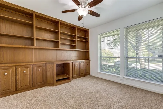a view of an empty room with a window and a kitchen