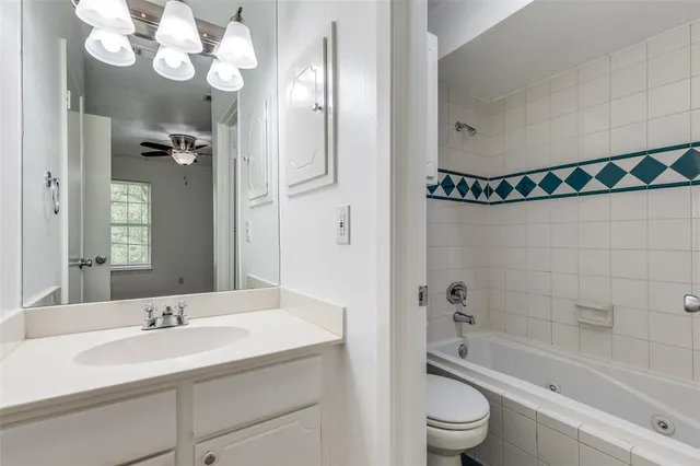 a bathroom with a sink a toilet a mirror and shower