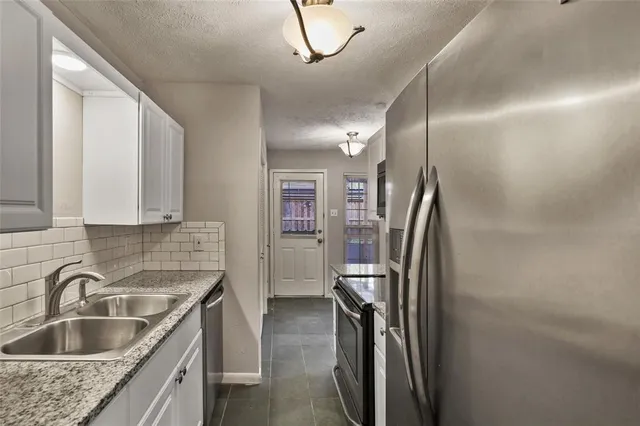 a kitchen with stainless steel appliances granite countertop a refrigerator and a sink