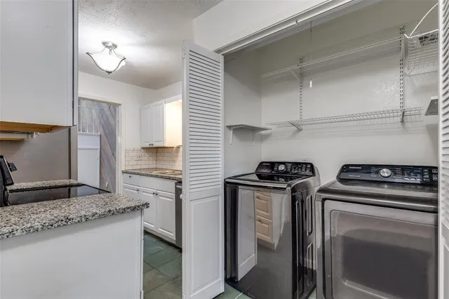 a kitchen with granite countertop a sink stove and refrigerator