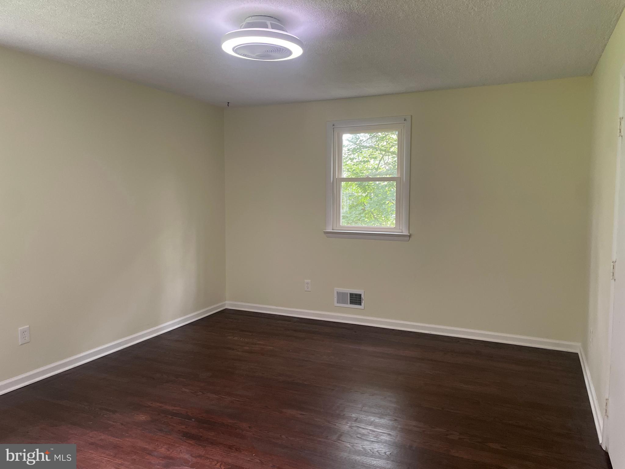 13409 Doncaster Lane Silver Spring, MD 20904 - Photo 22 of 37 an empty room with wooden floor and windows