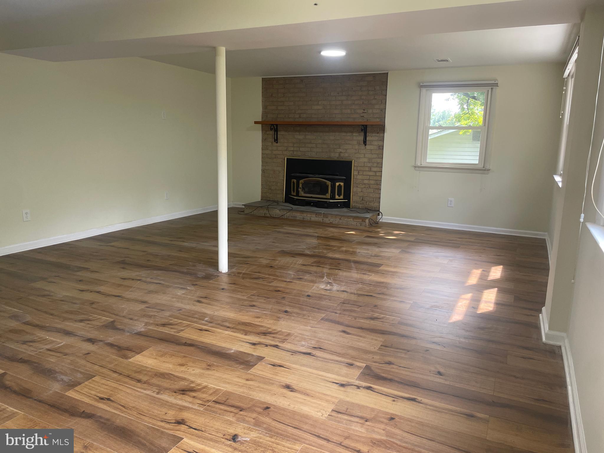 13409 Doncaster Lane Silver Spring, MD 20904 - Photo 27 of 37 an empty room with wooden floor fireplace and windows