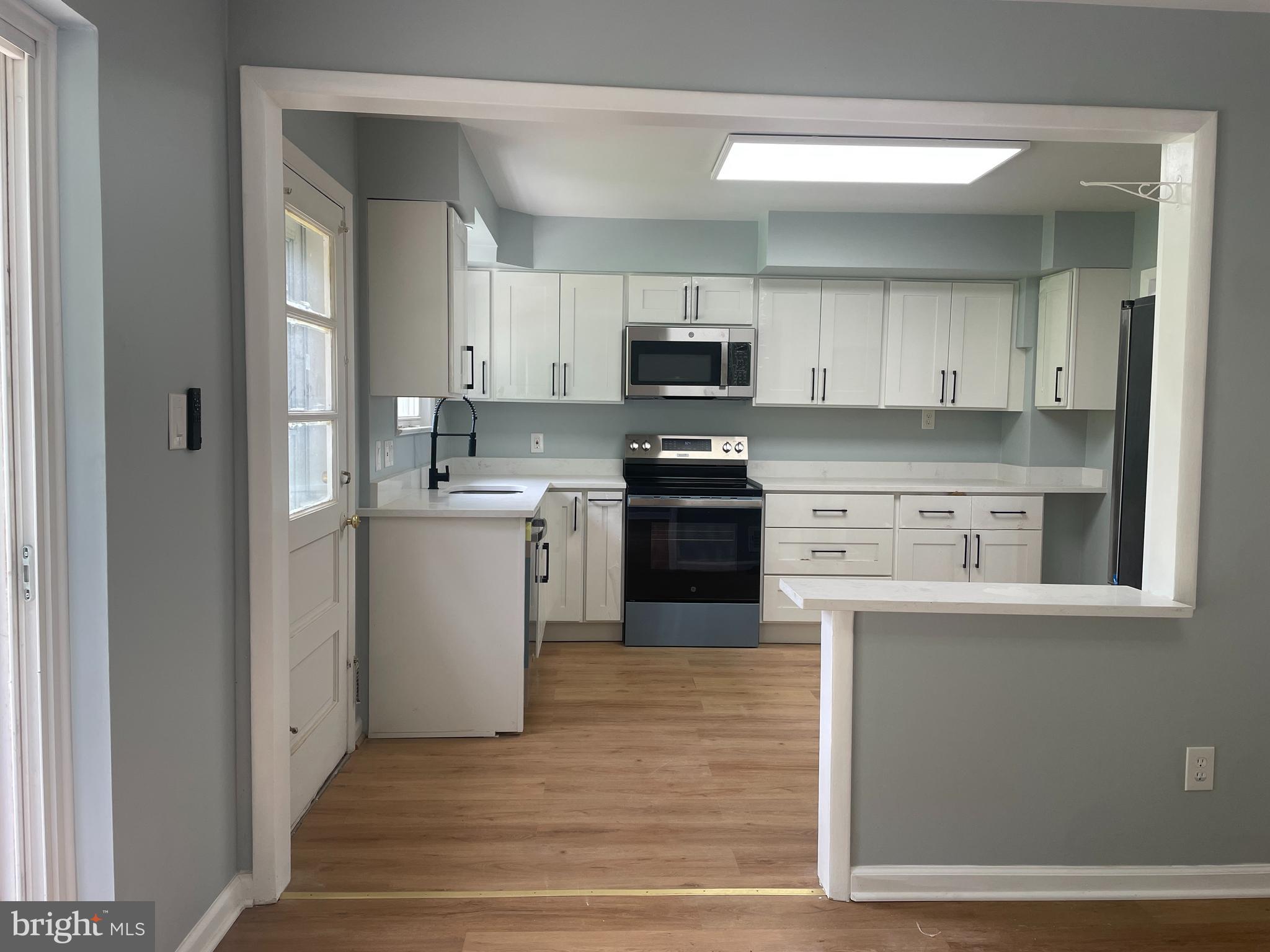 13409 Doncaster Lane Silver Spring, MD 20904 - Photo 7 of 37 a kitchen with stainless steel appliances granite countertop a stove top oven a sink and white cabinets