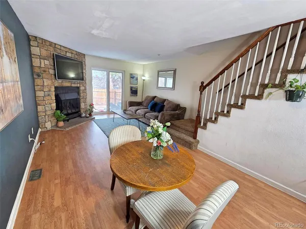 a view of a livingroom with furniture a fireplace and wooden floor