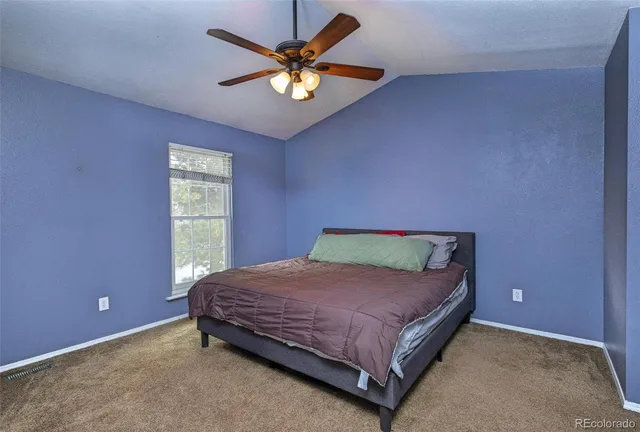 a bedroom with a bed and a ceiling fan