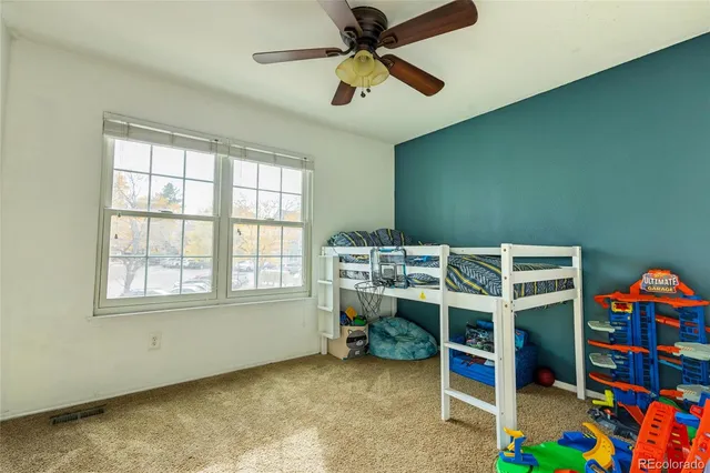 an empty room with a window and a ceiling fan