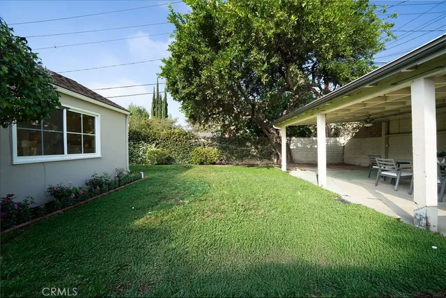 a view of a house with backyard and sitting area