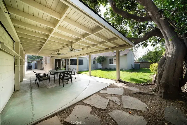 a view of a patio with table and chairs and floor to ceiling window